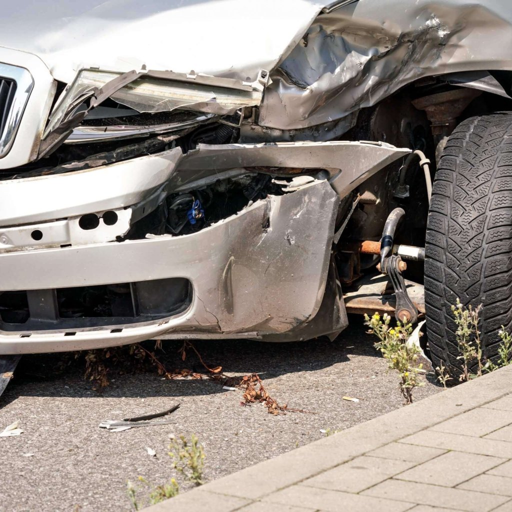 abgesturztes-silbernes-autowrack-detail-auf-der-vorderen-stossstange-verformte-metallplatten-und-reifen-scaled