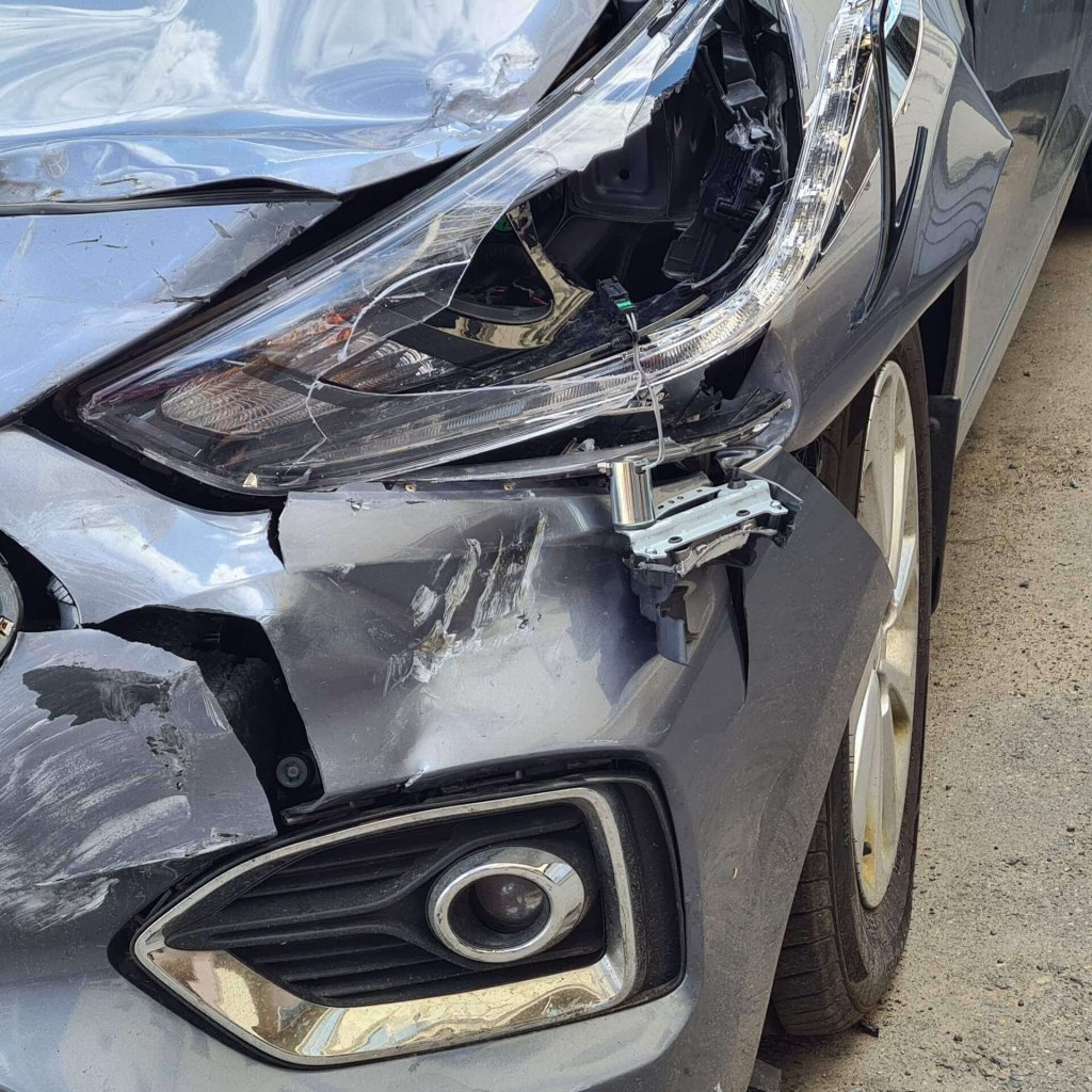 auto-mit-kaputter-scheinwerferhaube-und-stossstange-scaled